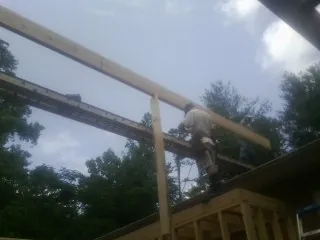 Carpenter setting a ridge beam over a new addition frame — Ice Dam Removal by Roofing Brothers in Neshkoro