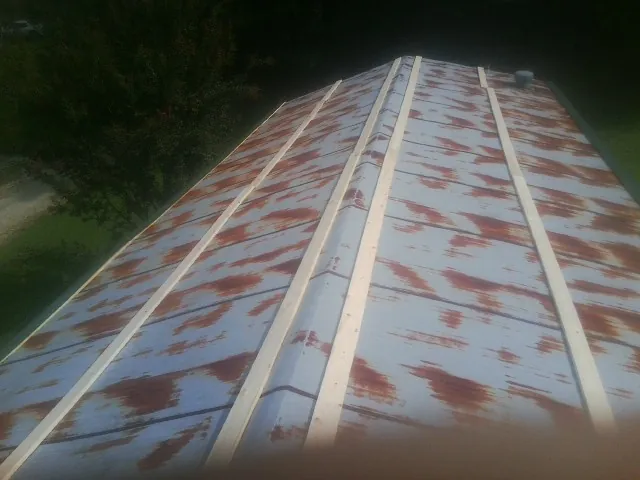 Rusted metal roof panels with new wood purlins before replacement — Storm Damage Roof Repair in Neshkoro by Roofing Brothers