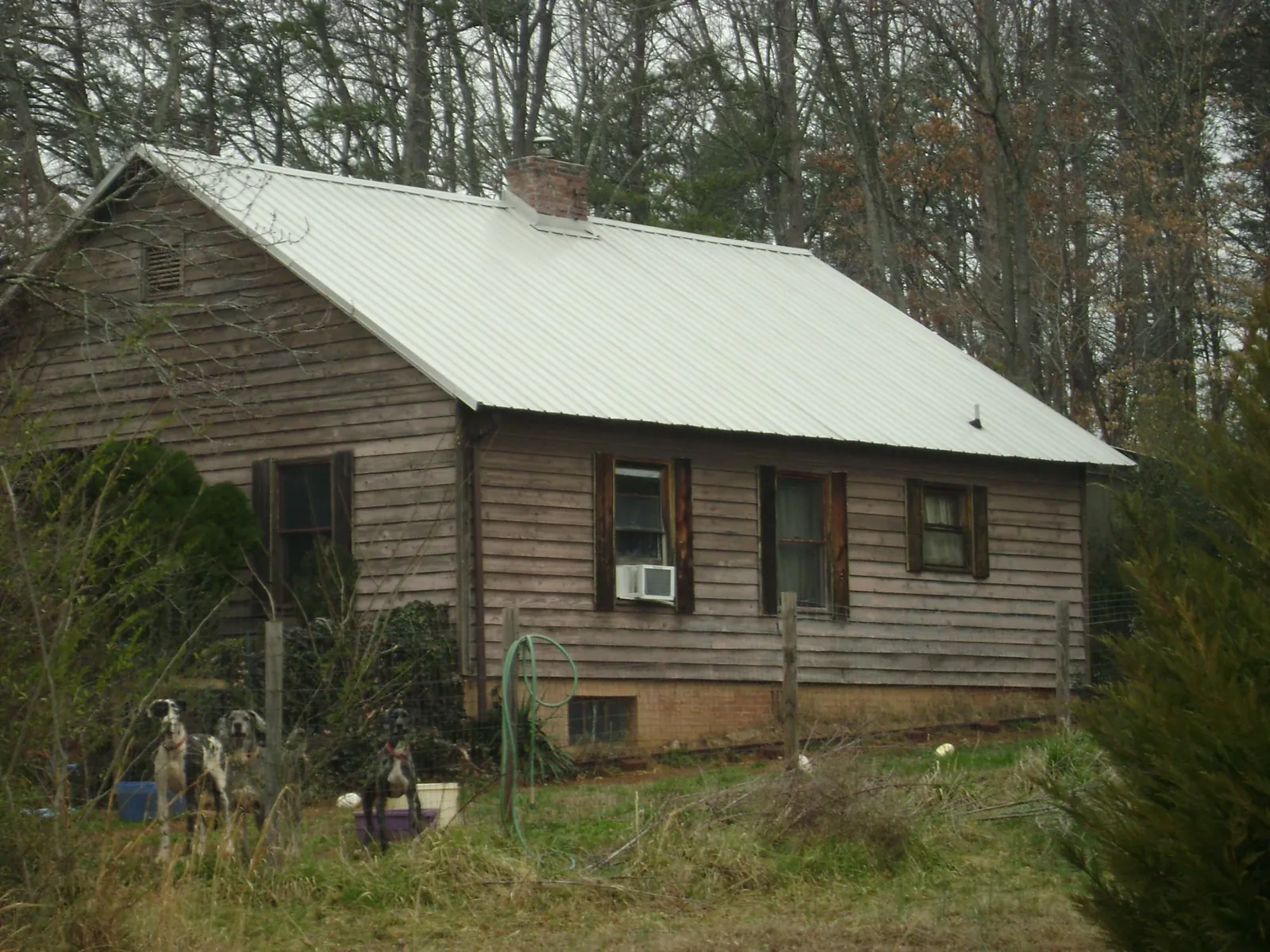White metal roof on an old wood sided farmhouse, from a Metal Roof Installation job in Neshkoro